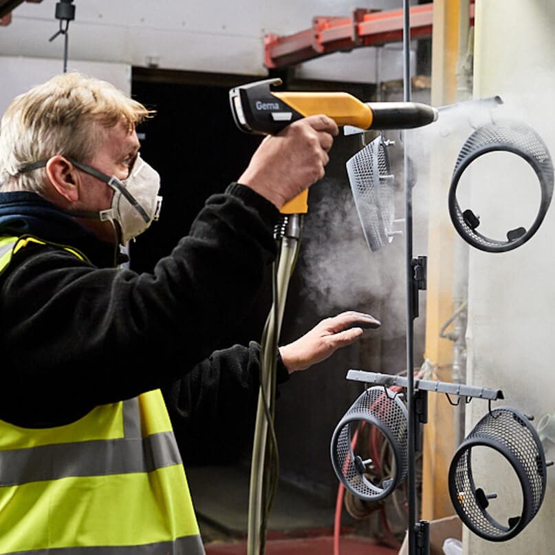 Man using powder coating equipment